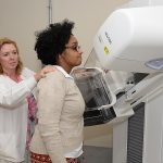 A technologist positioning a patient at a mammography machine