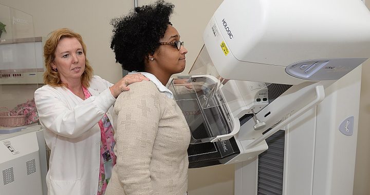 A technologist positioning a patient at a mammography machine
