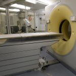 A CT scanner and patient table in a hospital imaging room