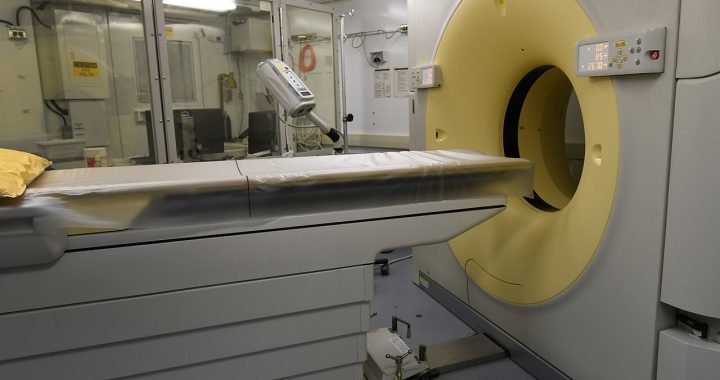 A CT scanner and patient table in a hospital imaging room