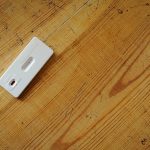 A rapid diagnostic test cassette on a wooden table